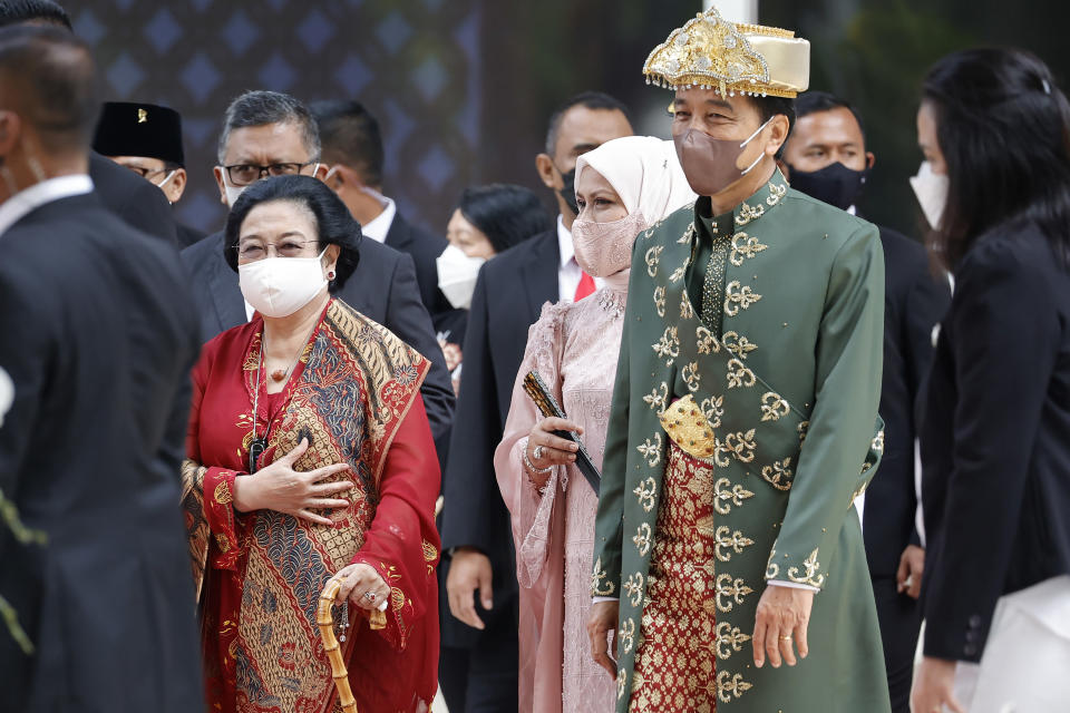 Indonesian President Joko Widodo, right, walks with the chairwoman of ruling Indonesian Democratic Party-Struggle (PDIP) Megawati Sukarnoputri, left, after delivering his annual state address ahead of the country's Independence Day, at the parliament building in Jakarta, Indonesia, Tuesday, Aug. 16, 2022. (Willy Kurniawan/Pool Photo via AP)