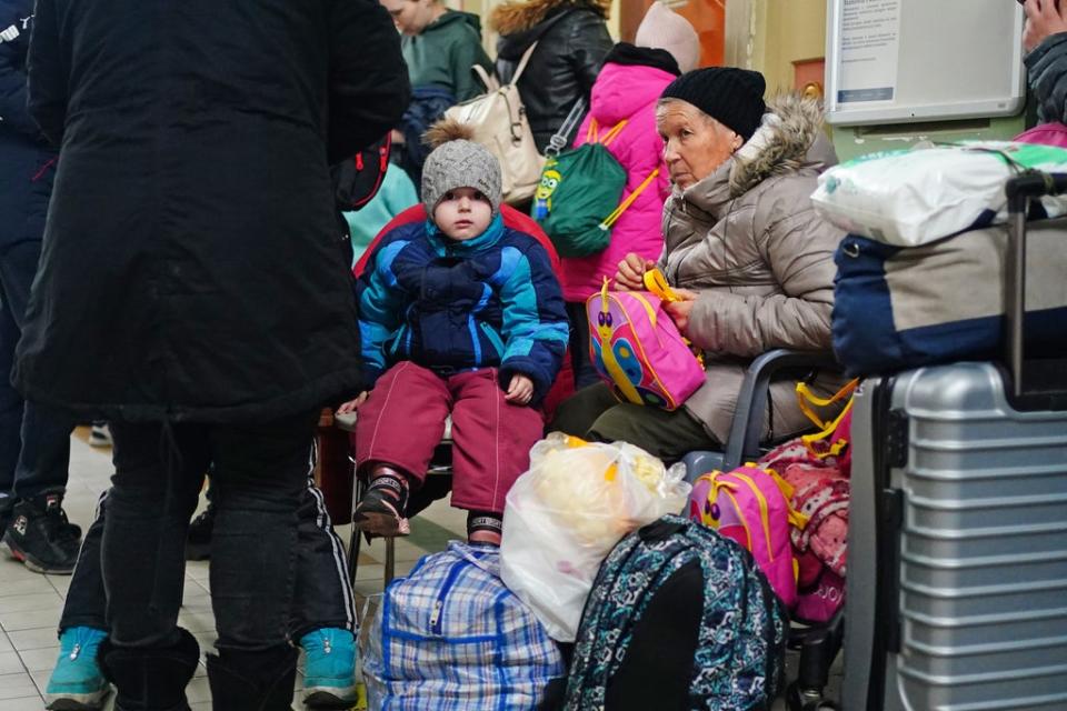 A family from Ukraine wait with their luggage at Przemysl train station in Poland (Victoria Jones/PA) (PA Wire)