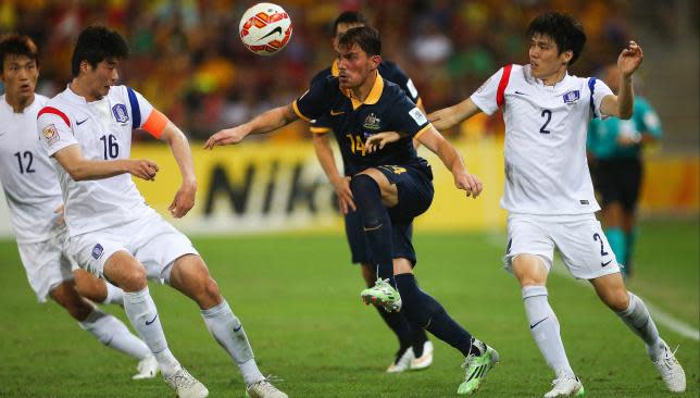 James Troisi (C) of Australia fights for the ball with Han Kyo Won (L), Ki Sung Yueng and Kim Changsoo (R) of South Korea.