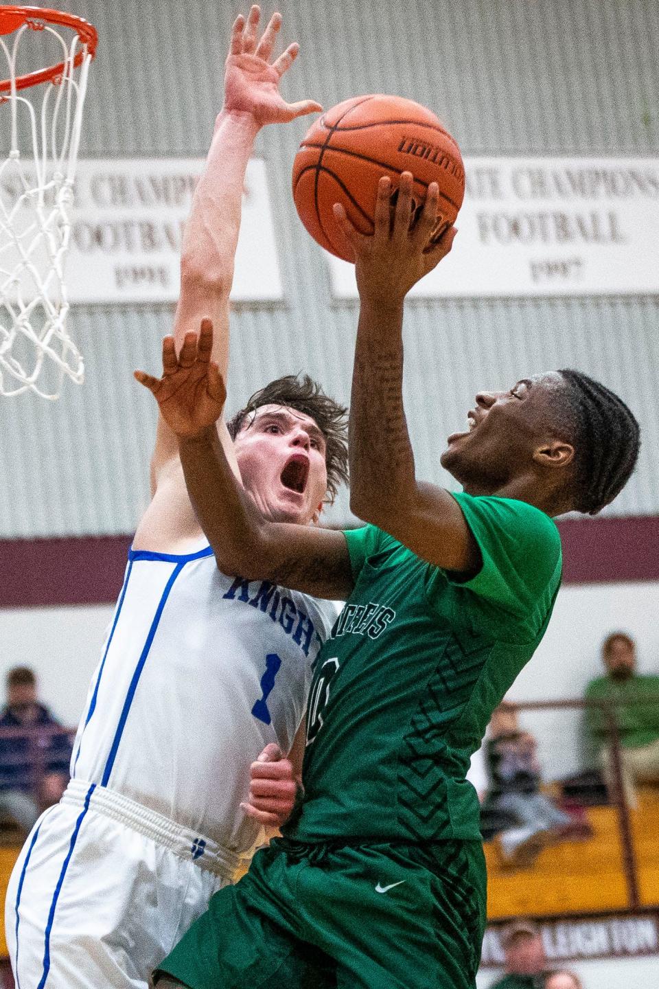 Washington's Terrence Reid (0) drives as Marian's Deaglan Sullivan (1) defends during the Marian vs. Washington sectional semifinal basketball game Friday, March 3, 2023 at Jimtown High School in Elkhart.
