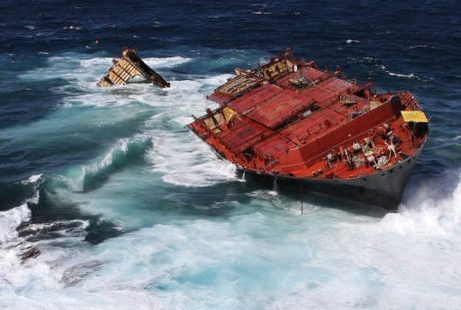 This file photo, released by Maritime New Zealand in April, shows the Liberian-flagged container ship 'Rena,' stuck on Astrolabe Reef as it is pounded by high seas off the coast of Tauranga. The captain and second officer of the ship that caused N.Zealand's biggest sea pollution disaster have both been jailed for seven months