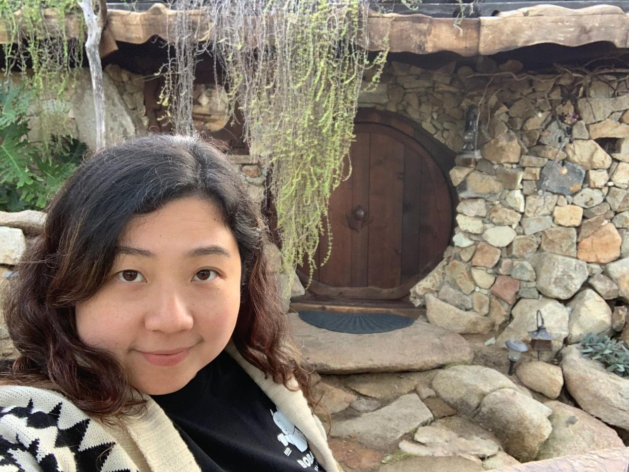 Fiona Chandra selfie in front of the Hobbit House north of San Diego, "I paid $412 to Stay in a Hobbit House. "