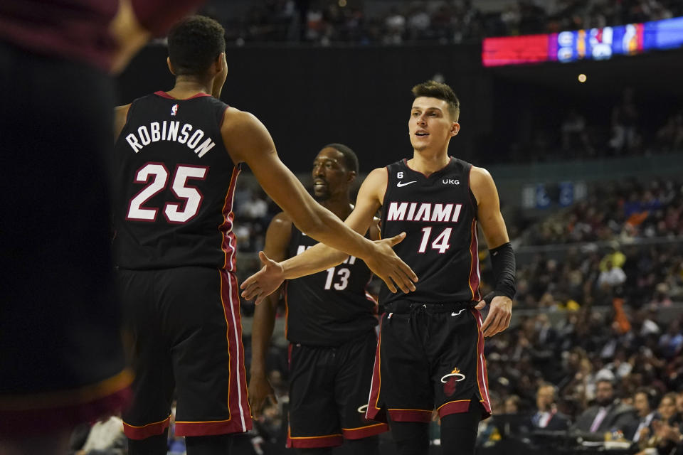 Miami Heat's Tyler Herro, right, slap hands with Orlando Robinson during the second half of an NBA basketball game against San Antonio Spurs, at the Mexico Arena in Mexico City, Saturday, Dec. 17, 2022. (AP Photo/Fernando Llano)