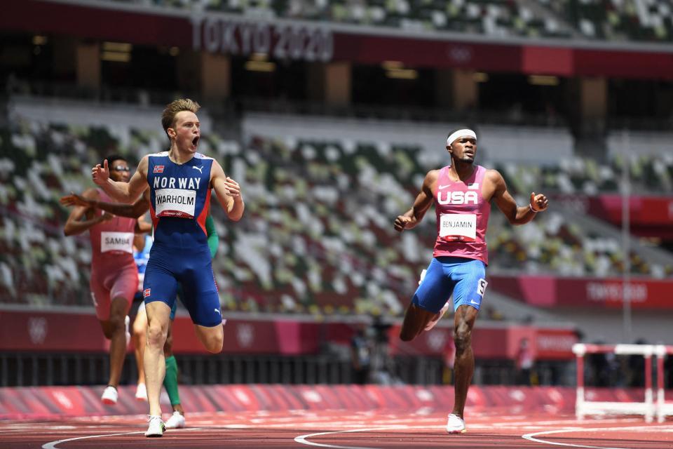 Norway's Karsten Warholm (L) reacts as he wins and breaks the world record ahead of second-placed  USA's Rai Benjamin (R) in the men's 400m hurdles final during the Tokyo 2020 Olympic Games.