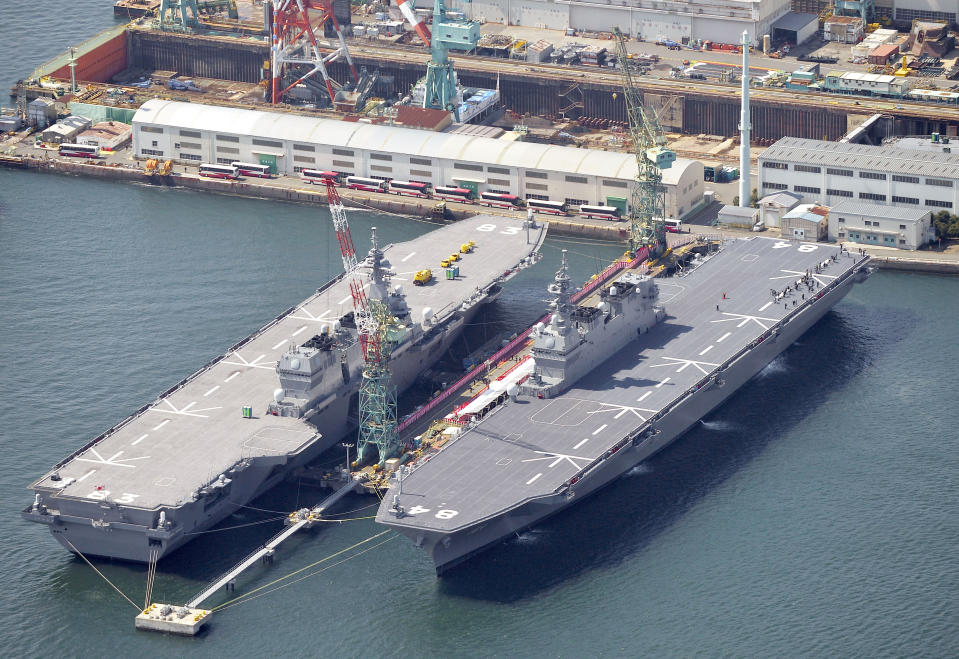 FILE - In this March 22, 2017, file photo, Japan Maritime Self-Defense Force's helicopter carrier Kaga, right, along with Izumo, left, is seen in Yokohama, south of Tokyo. Japan's Defense Ministry is seeking a record-high budget of nearly 5.5 trillion yen ($55 billion) for fiscal 2021 fund more purchases of costly American stealth fighters and expand its capability to counter possible threats in both cyber and outer space.(Yoshitaka Sugawara/Kyodo News via AP, File)