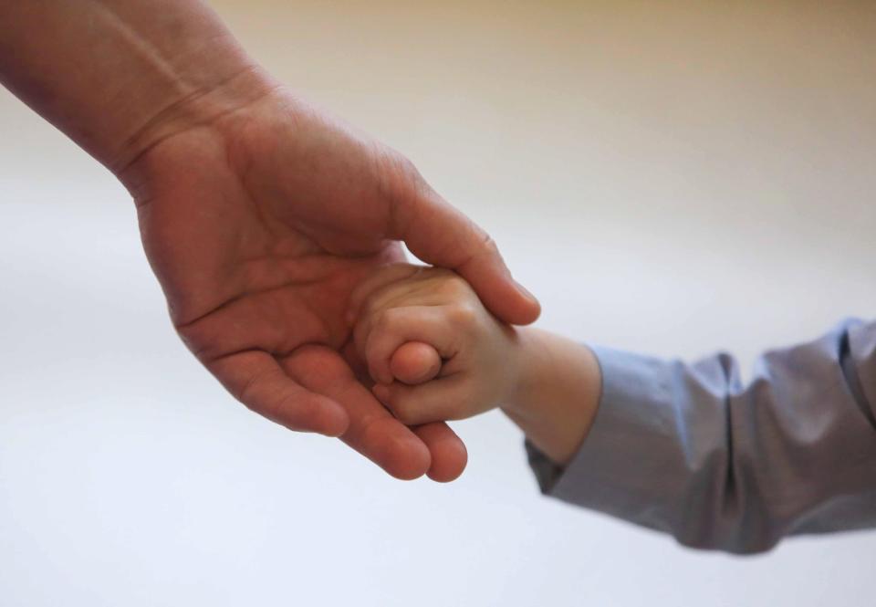 A child’s hand is held.