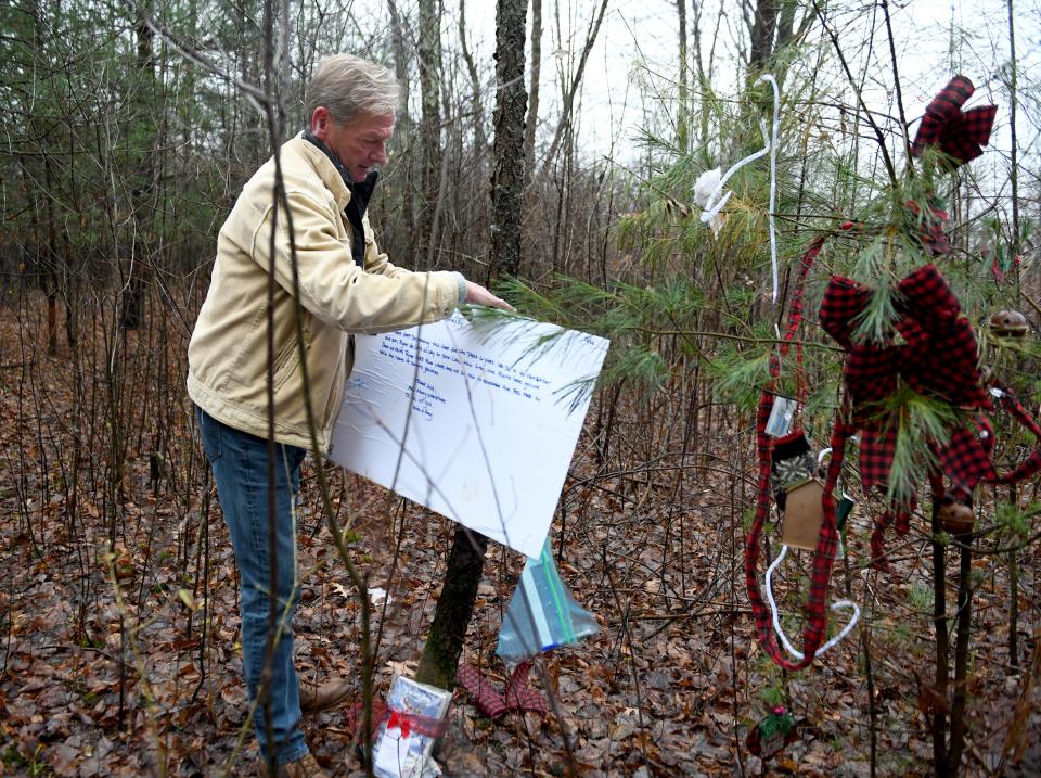 Michael Wozniak adjusts a sign next to the R.Y.A.N. Tree. November 30, 2022