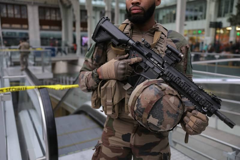 A French soldier of the Sentinelle security operation stands guard in front of a security perimeter after a knife attack at Paris's Gare de Lyon railway station, a major travel hub. Police said that the suspected attacker had been arrested and that the motives behind the attack were unclear. Thomas Samson/AFP/dpa