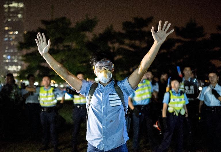 A democracy protester raises his hands in front of police in Hong Kong, October 15, 2014. Some officers have been 'removed' from their posts