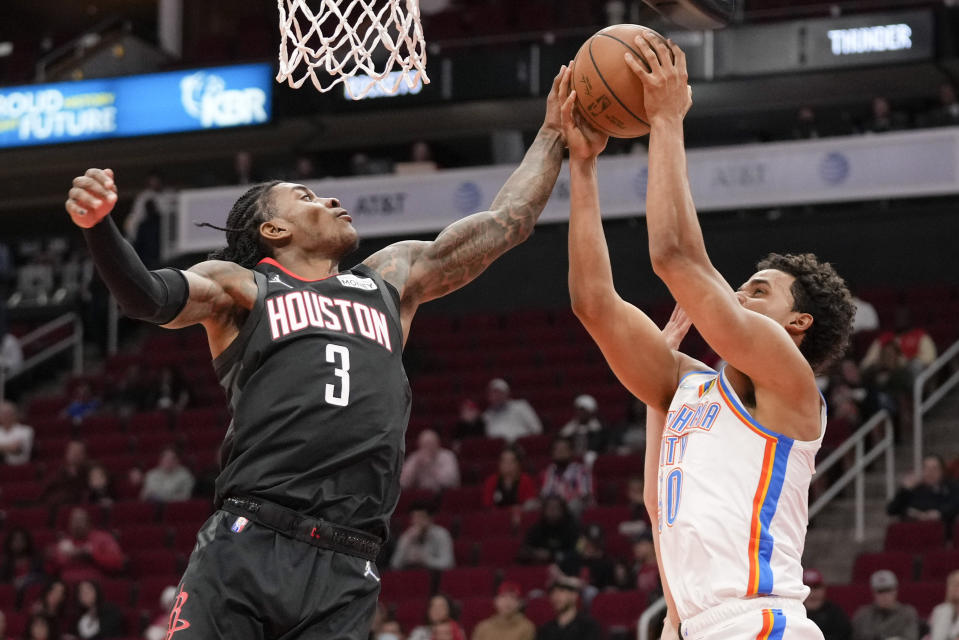 Oklahoma City Thunder forward Jeremiah Robinson-Earl, right, shoots as Houston Rockets guard Kevin Porter Jr. (3) defends during the first half of an NBA basketball game, Monday, Nov. 29, 2021, in Houston. (AP Photo/Eric Christian Smith)