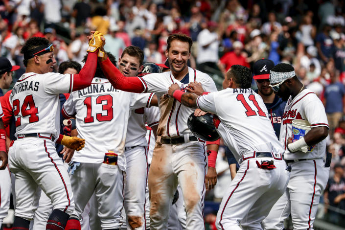 Atlanta Braves' Matt Olson, center celebrates with teammates after he scored the winning run on a hit by Austin Riley during the ninth inning of a baseball game against the Arizona Diamondbacks, Sunday, July 31, 2022, in Atlanta. (AP Photo/Butch Dill)