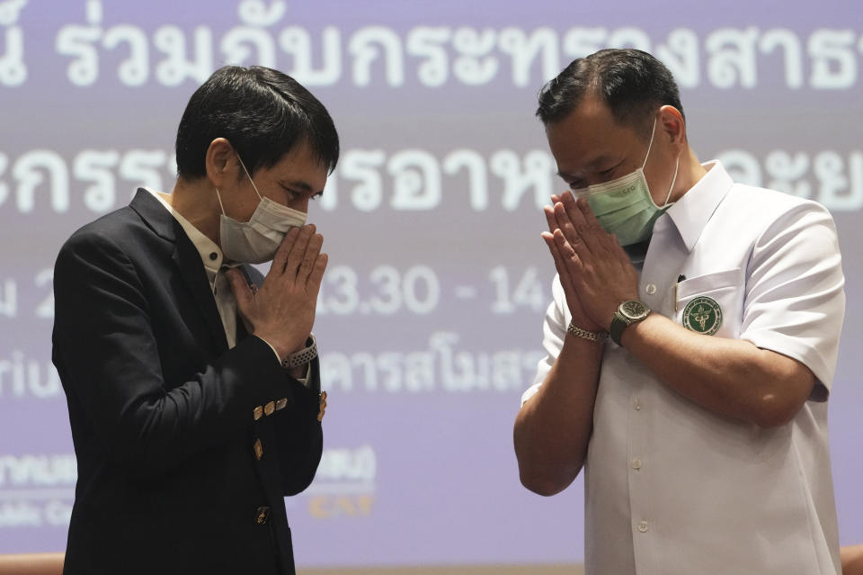 Secretary General of The Chulabhorn Royal Academy Nithi Mahanonda, left, and Thailand's Public Health Minister Anutin Charnvirakul give the traditional greeting or "wai" after a press conference in Bangkok, Thailand, Friday, May 28, 2021. The Chulabhorn Royal Academy, a Thai government research agency associated with the country's royal family said Friday it will purchase and import the Chinese-made COVID-19 vaccine Sinopharm, setting up a distribution channel separate from the government's free vaccination program. It said the first shipment of 1 million doses is supposed to be delivered in June, which should boost Thailand's lagging rate of vaccinations. (AP Photo/Sakchai Lalit)