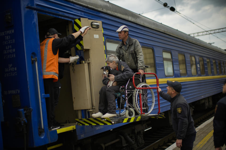 People fleeing from shelling board an evacuation train at the train station, in Pokrovsk, eastern Ukraine, Sunday, May 22, 2022. Civilians fleeing areas near the eastern front in the war in Ukraine Sunday described scenes of devastation as their towns and villages came under attack from Russian forces. (AP Photo/Francisco Seco)