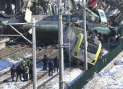 Members of rescue services work at the scene of a train accident in Ankara, Turkey, Thursday, Dec. 13, 2018. A high-speed train hit a railway engine and crashed into a pedestrian overpass at a station in the Turkish capital Ankara on Thursday, killing more than 5 people and injuring more than 40 others, officials and news reports said. (AP Photo/Burhan Ozbilici)