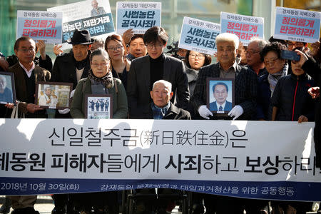 Lee Choon-shik, a victim of wartime forced labor during the Japanese colonial period, arrives with supporters holding portraits of fellow deceased laborers in Seoul, South Korea, October 30, 2018. REUTERS/Kim Hong-Ji