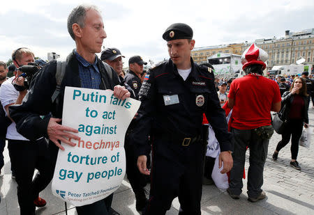 Veteran British LGBT rights campaigner Peter Tatchell is detained by a police officer during a one-man protest to draw attention to what he said were appalling human rights abuses committed against gay men in Chechnya, in central Moscow, Russia June 14, 2018. REUTERS/Glab Garanich