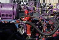 FILE - This March 25, 2014 file photo shows a worker adjusting hoses during a hydraulic fracturing operation at an Encana Corp. gas well, near Mead, Colo. The energy boom is scrambling national politics. Democrats are split between environmentalists and business and labor groups. Some deeply-conservative areas are allying with conservationists against fracking, the technique largely responsible for the surge. (AP Photo/Brennan Linsley, File)