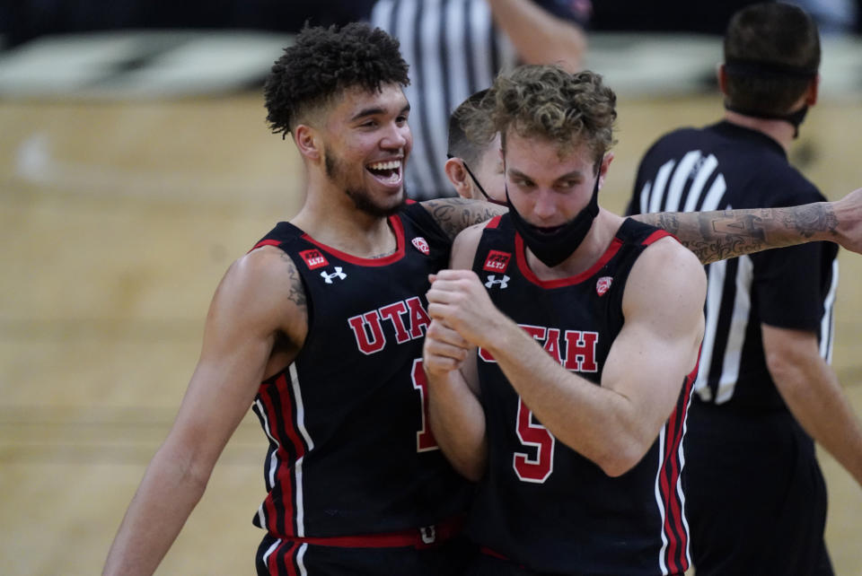 Utah forward Timmy Allen, left, jokes with guard Jaxon Brenchley in the second half of an NCAA college basketball game against Colorado, Saturday, Jan. 30, 2021, in Boulder, Colo. Utah won 77-74. (AP Photo/David Zalubowski)