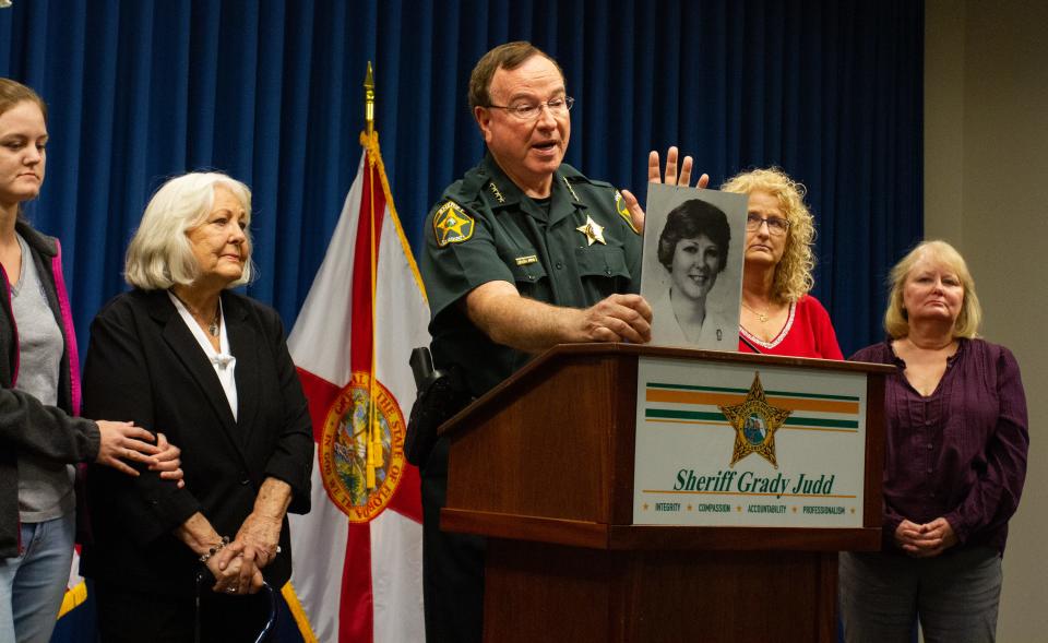 Polk County Sheriff Grady Judd is surrounded by relatives of Teresa Scalf at a news conference Monday as he announces that PCSO identified Donald Douglas as her killer.
