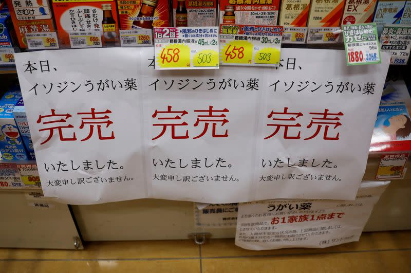 FILE PHOTO: Banners notifying sold-out of gargling medicine are displayed at empty shelves at a drugstore in Tokyo