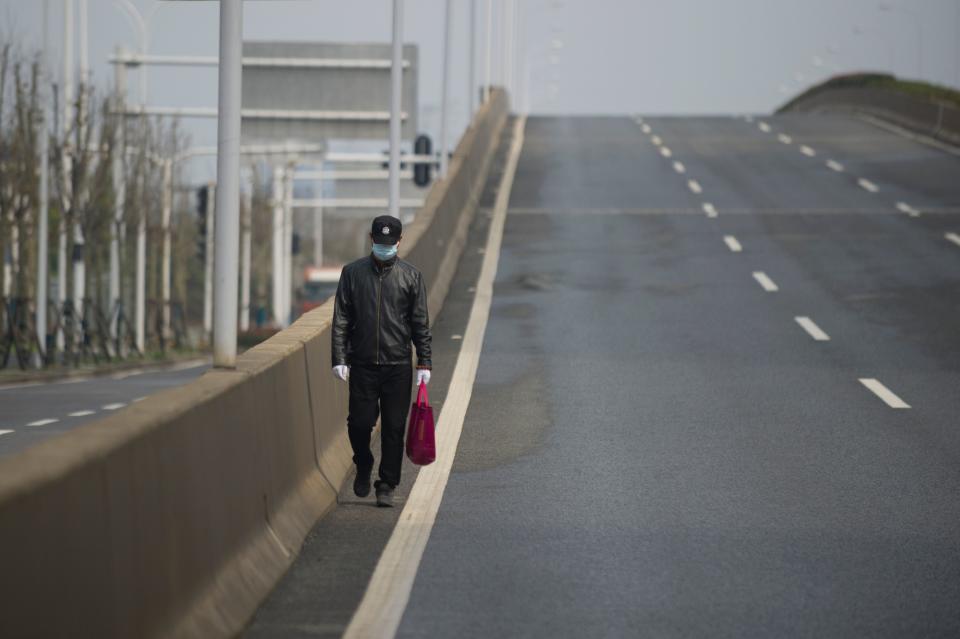 A man walks on an empty street in Wuhan, in China's central Hubei province on February 29, 2020. - Wuhan's 11 million resident have been under effective quarantine since January 23 as Chinese authorities race to contain the COVID-19 coronavirus outbreak. (Photo by STR / AFP) / China OUT (Photo by STR/AFP via Getty Images)