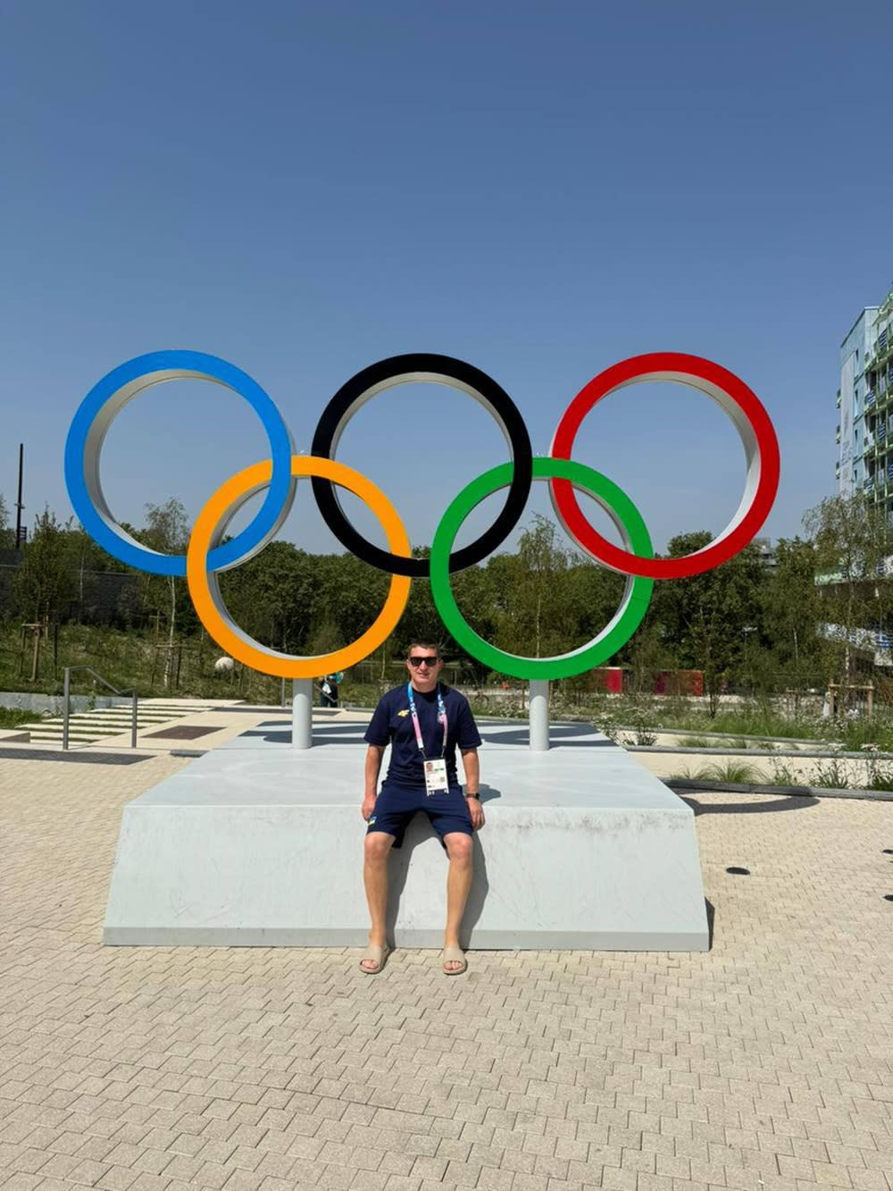 Man sitting in front of Olympic rings