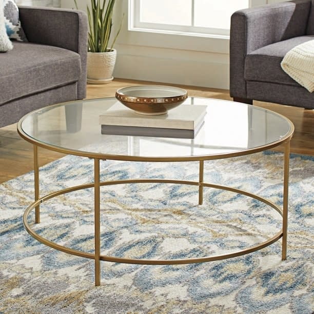 The round table with books and decorative bowl resting on top