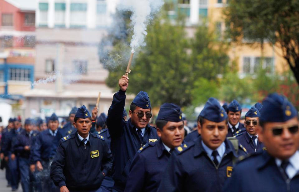 A member of the Air Force launches a fire cracker on the second day of protests in La Paz, Bolivia, Wednesday, April 23, 2014. Hundreds of low ranking soldiers from Bolivia's Armed Forces marched for a second day against the military high command's dismissal of four of its leaders who defended their call for more career opportunities. The Ministry of Defense has threatened to discharge the soldiers who continue to protest. (AP Photo/Juan Karita)