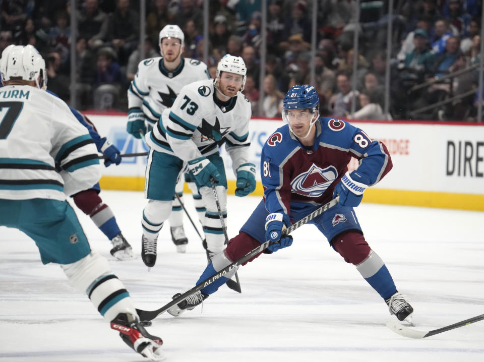 Colorado Avalanche center Denis Malgin, center, looks to pass the puck as San Jose Sharks center Nico Sturm, front, and center Noah Gregor defend in the third period of an NHL hockey game Tuesday, March 7, 2023, in Denver. (AP Photo/David Zalubowski)