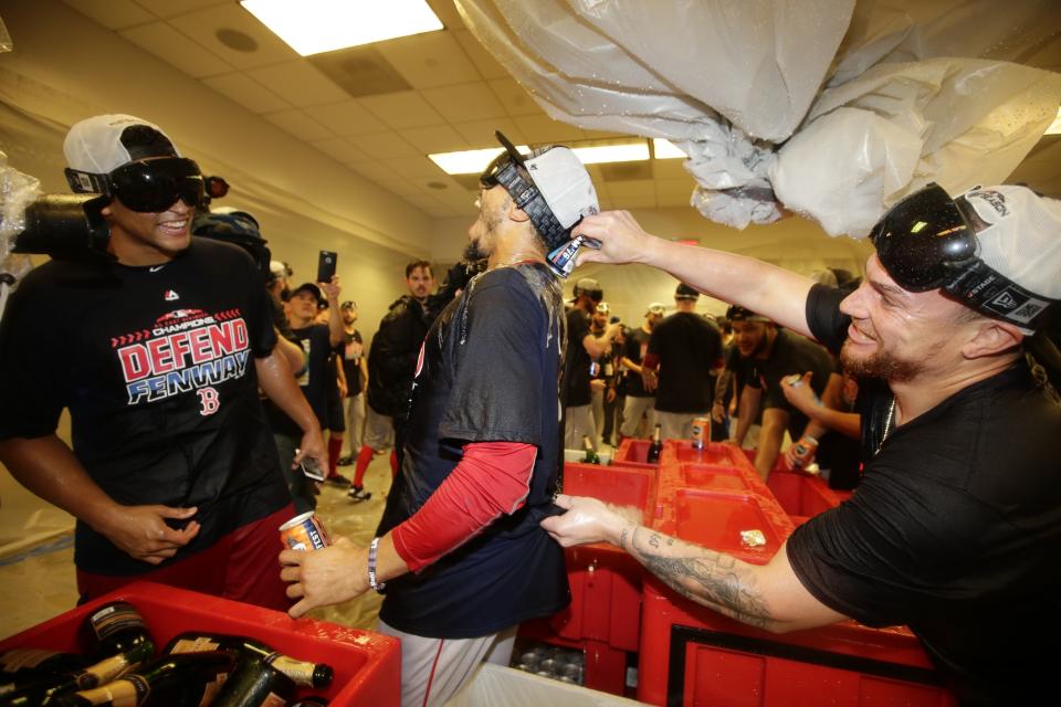 Boston Red Sox's Mookie Betts, center, celebrates with teammates after they clinched the AL East title Thursday, Sept. 20, 2018, in New York. The Red Sox defeated the New York Yankees 11-6. (AP Photo/Frank Franklin II)