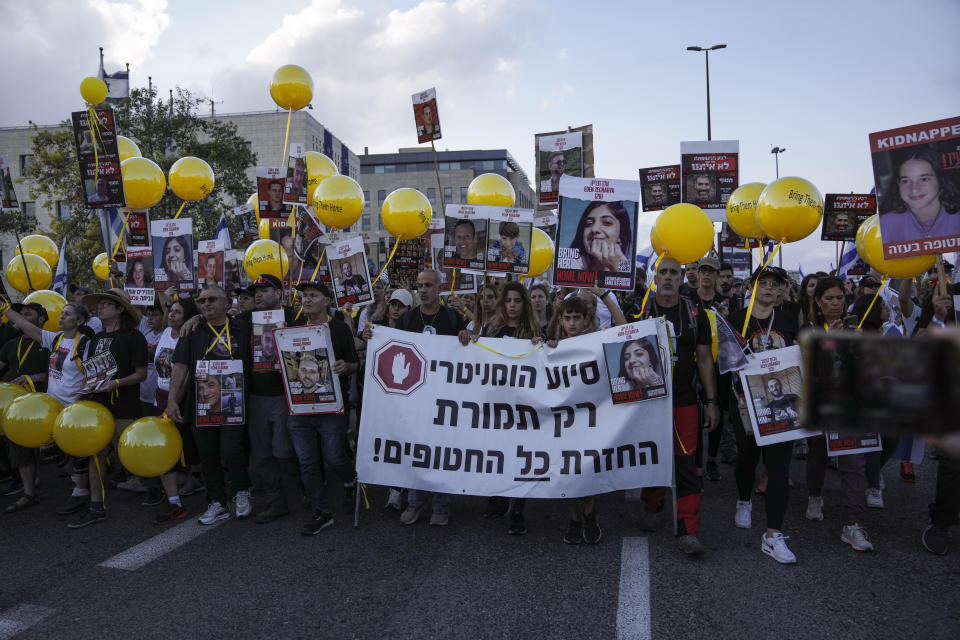 Family and supporters of the estimated 240 hostages held by Hamas in Gaza complete the final leg of a five-day solidarity rally calling for their return, from Tel Aviv to the Prime Minister's office in Jerusalem, Saturday, Nov. 18, 2023. The hostages, mostly Israeli citizens, were abducted during the brutal Oct. 7 Hamas cross-border attack in Israel and have been held in the enclave since as war rages. Hebrew banner reads, "Humanitarian aid only in exchange for all the abductees״. (AP Photo/Mahmoud Illean)