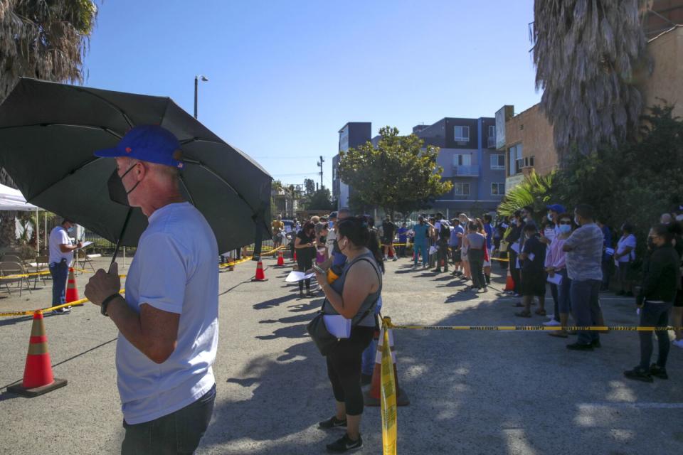 People wait in line to get vaccinated against monkeypox at a St. John's Community Health site in Los Angeles.