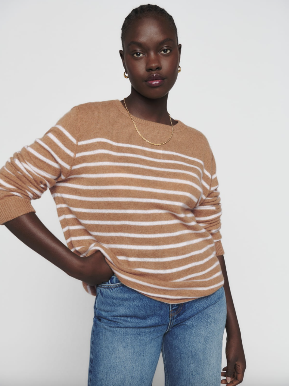 woman wearing brown and white striped Cashmere Boyfriend Sweater and blue jeans (photo via Reformation)