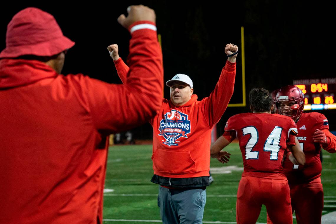 Kennedy Catholic head coach Sheldon Cross holds up his arms victoriously with less than a minute remaining in the fourth quarter of a Class 4A state quarterfinal game Skyline on Friday, Nov. 18, 2022, at Highline Memorial Stadium in Burien, Wash. Kennedy Catholic beat Skyline, 38-10.