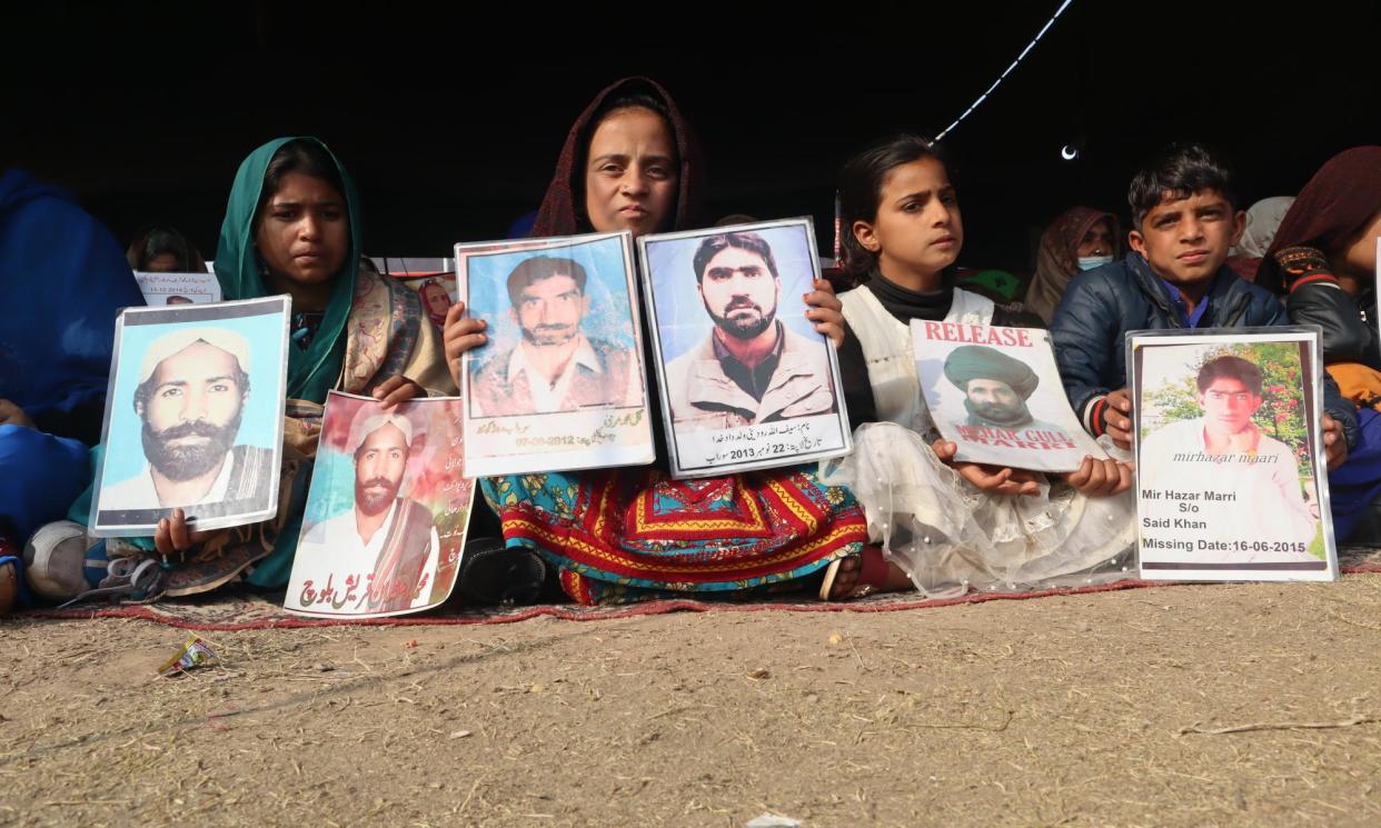 <span>Anisa Ramzan, left, with a picture of her missing father, with other children who have lost family members, at a protest camp in Islamabad in January.</span><span>Photograph: Shah Meer Baloch</span>