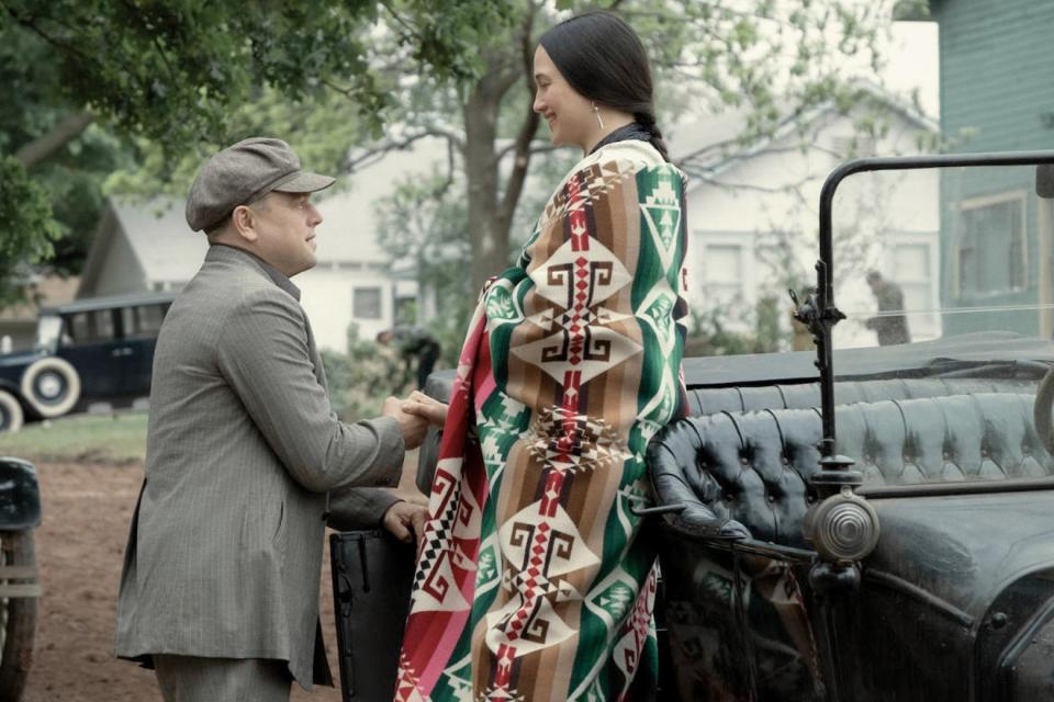 Leonardo Di Caprio helps Lily Gladstone down from a 1920s car in a scene from the movie. 
