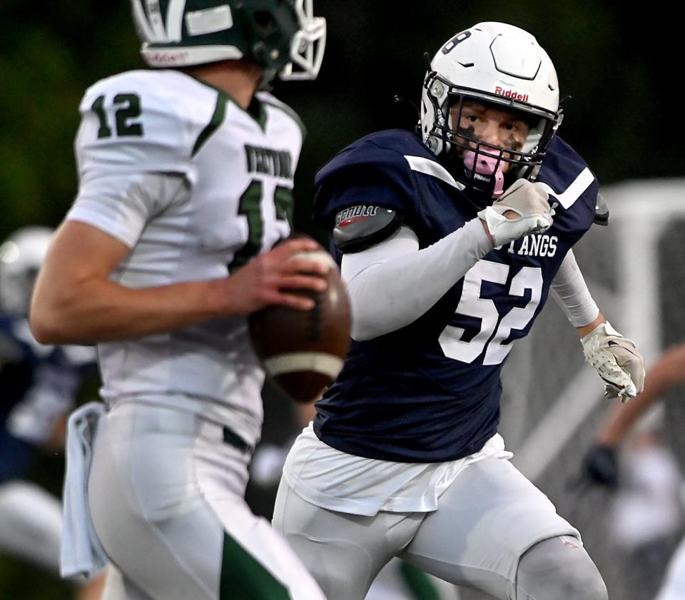 Medway's Brett Curran chases down Westwood quarterback Brendan Donegan during the first half at Medway High School, Sept. 29, 2022.