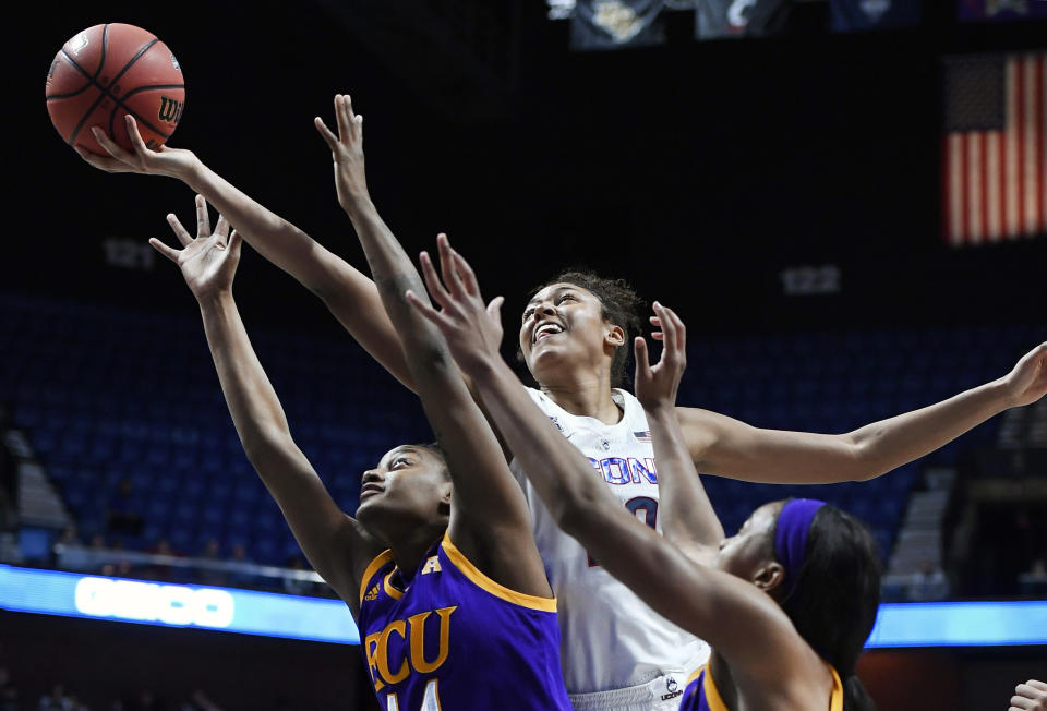 Connecticut's Olivia Nelson-Ododa reaches for a rebound over East Carolina's Destiny Campbell, left, and Raven Johnson, right, during the first half of an NCAA college basketball game in the American Athletic Conference tournament quarterfinals, Saturday, March 9, 2019, at Mohegan Sun Arena in Uncasville, Conn. (AP Photo/Jessica Hill)