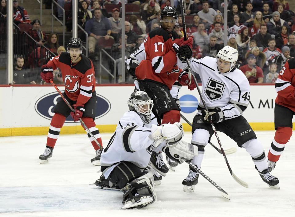 Los Angeles Kings goaltender Calvin Petersen (40) gloves the puck as Kings center Blake Lizotte (46) checks New Jersey Devils right wing Wayne Simmonds (17) during the second period of an NHL hockey game Saturday, Feb. 8, 2020, in Newark, N.J. (AP Photo/Bill Kostroun)