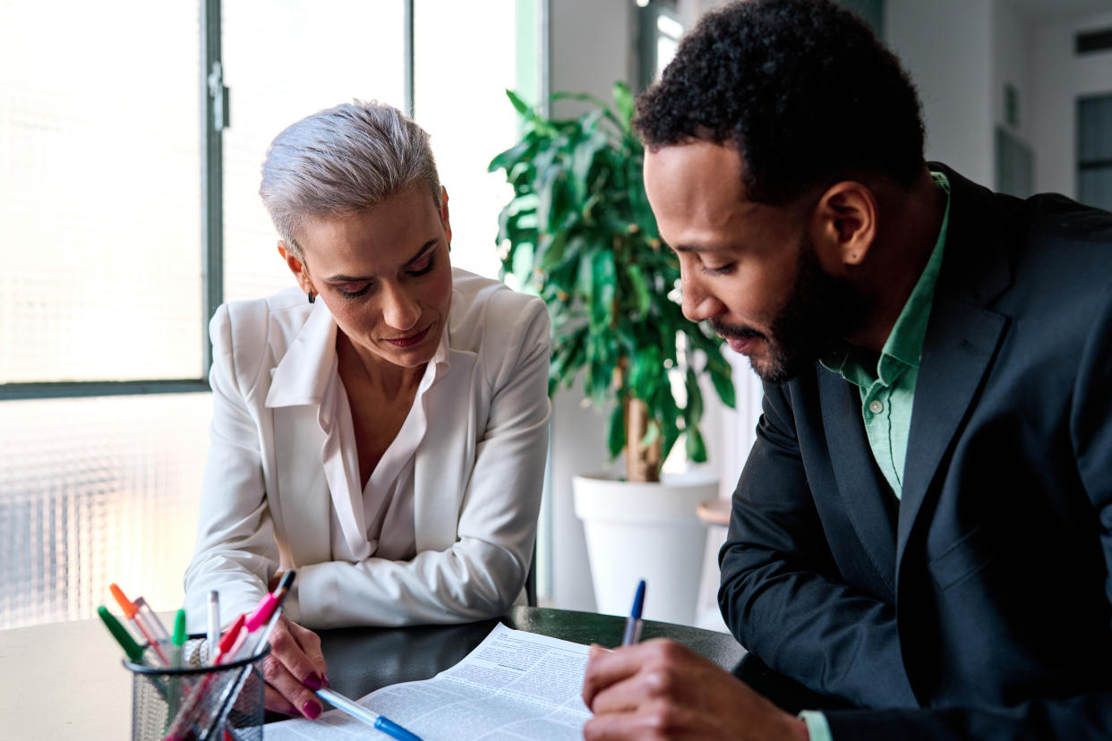 Lawyer reading a document during a meeting with a customer, gender pay gap.