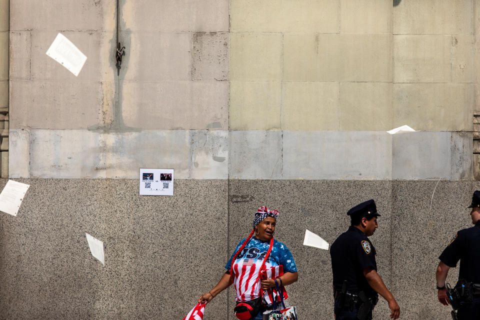 A woman walks along the parade route as papers and ticker tape falls.&nbsp; (Photo: Demetrius Freeman for HuffPost)