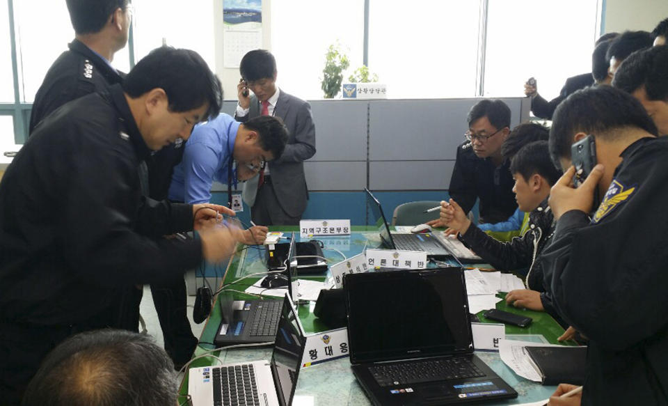 South Korea coast guard police officers work to rescue passengers from a South Korean passenger ship, at Mokpo Coast Guard in Mokpo, south of Seoul, South Korea, Wednesday, April 16, 2014. A government office said the passenger ship carrying about 470 people has sent a distress call off the southern coast after it began leaning to one side. (AP Photo/Cho Keun-young, Yonhap) KOREA OUT