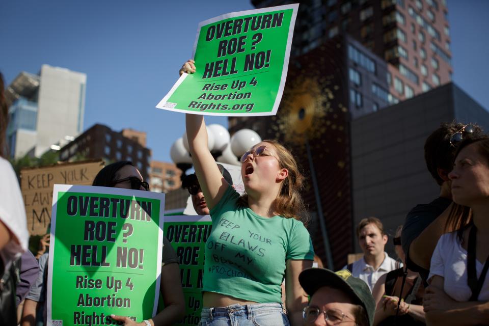 A woman holds up a sign at a protest.