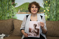 In this photo taken on Sunday, Feb. 10, 2019, Tatyana Rybalchenko, who worked as a nurse during the Soviet campaign in Afghanistan between 1986 and 1988, holds a photo of her taken in June 1986 in Kabul, Afghanistan, during her interview with The Associated Press in Moscow, Russia. As Russia this week marks the 30th anniversary of the withdrawal of the Soviet troops, the memories of the war are still fresh for female nurses and clerks and shopkeepers, mostly young and single, who were thrust into the disastrous campaign that came to known as Russia's Vietnam. (AP Photo/Alexander Zemlianichenko)