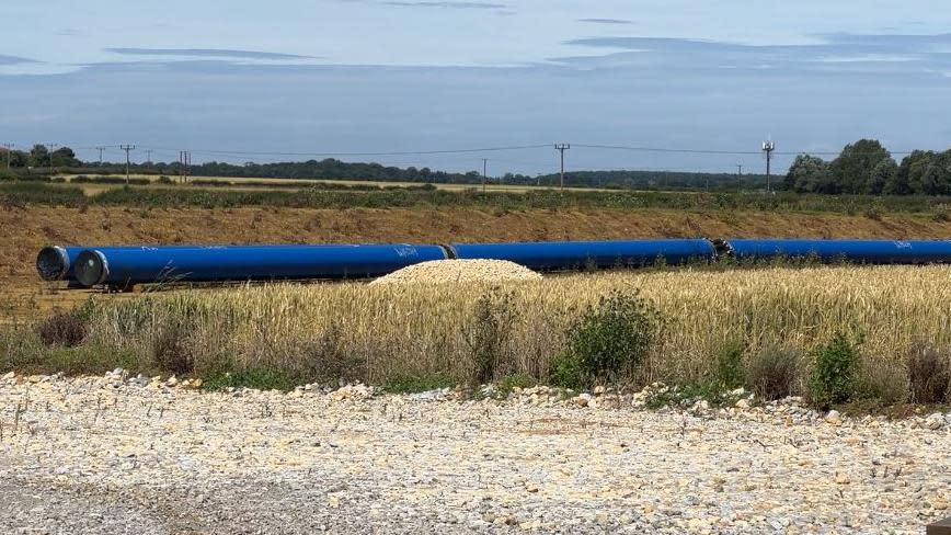 Sections of blue plastic pipe in an arid field