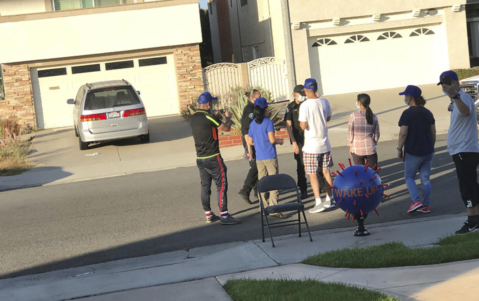 Chinese protesters shout slogans and display a Covid-19 virus inflatable outside Wu Jianmin's home in Irvine, Calif., in 2020. American officials say foreign countries like Iran and China intimidate, harass and sometimes plot violence against political opponents and activists in the U.S. For Jianmin, The harassment lasted more than two months. (Wu Jianmin via AP)