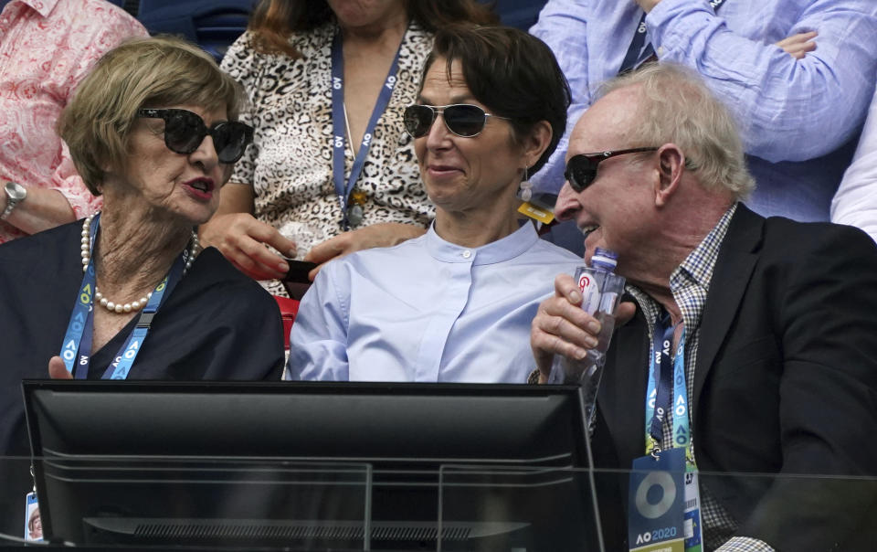 Former Australian Open champions, Margaret Court, left, chats with Rod Laver, right, as they watch the fourth round singles match between SerbiaÅfs Novak Djokovic and Diego Schwartzman of Argentina at the Australian Open tennis championship in Melbourne, Australia, Sunday, Jan. 26, 2020. (AP Photo/Lee Jin-man)