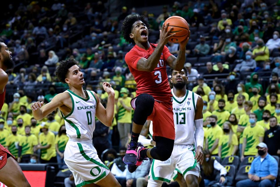 SMU guard Kendric Davis (3) drives past Oregon guard Will Richardson (0) and forward Quincy Guerrier (13) during the second half of an NCAA college basketball game Friday, Nov. 12, 2021, in Eugene, Ore. (AP Photo/Andy Nelson)