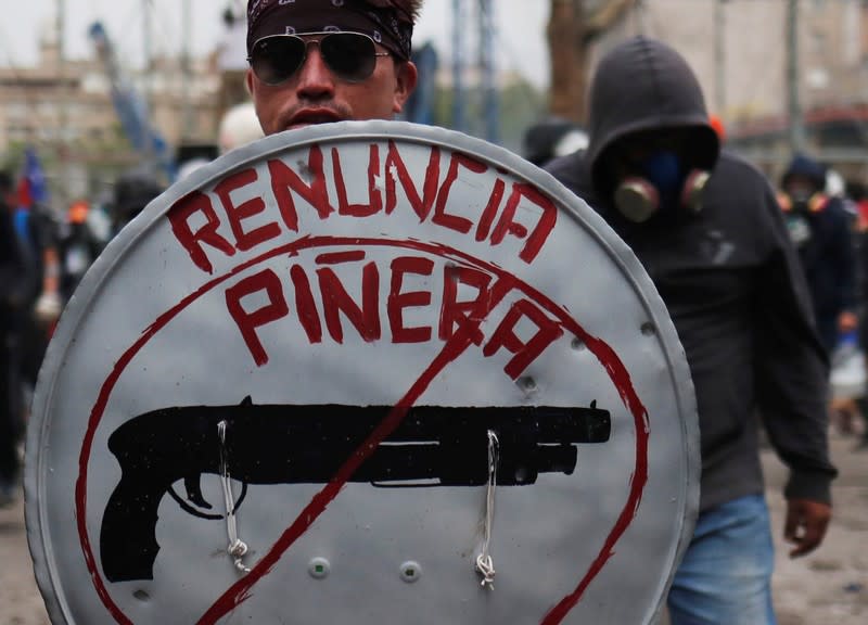 Un manifestante se protege con un escudo improvisado durante una protesta contra el gobierno en Santiago de Chile