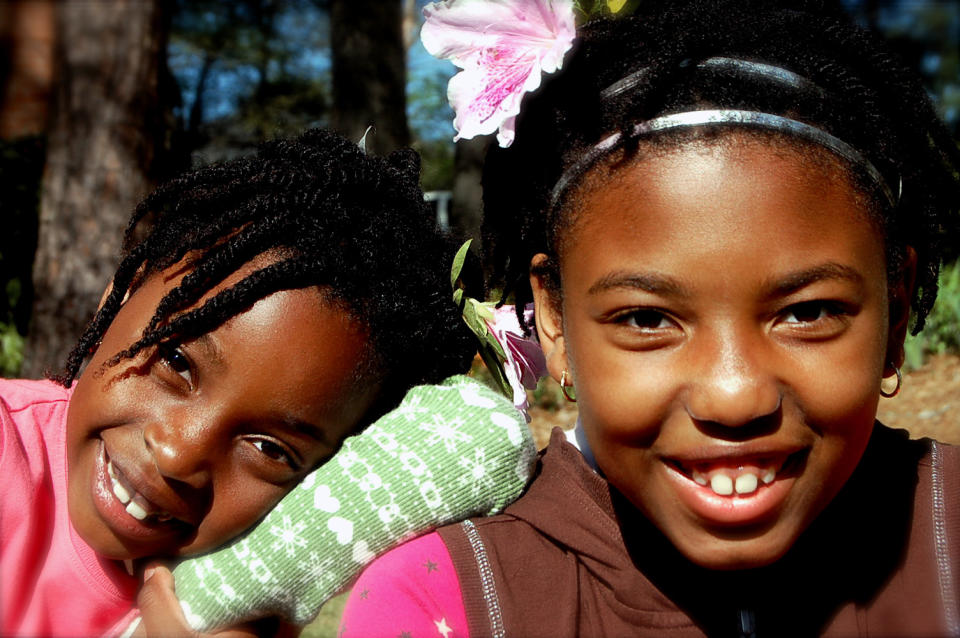 This 2009 photo released by author and blogger Denene Millner shows her daughters, Lila Chiles, 7, left, and Mari Chiles in Snellville, Ga. Millner chose to wear her hair natural nearly 14 years ago for the sake of her daughters, now 14 and 11. "I didn't want them to grow up with the same idea that I had when I was little, that there was something wrong with the way that my hair grew out of my head." (AP Photo/Denene Millner)